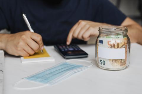 Personne avec une calculette notant les frais de remboursement