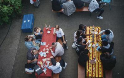 Un moment convivial au BAZAR SINGA, où réfugiés et Bruxellois se rencontrent dans une ambiance chaleureuse et dynamique.