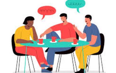 3 personnes discutant à une table